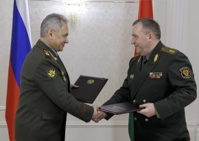 Руският министър на отбраната Сергей Шойгу (вляво) и беларуският министър на отбраната Виктор Хренин разменят документи по време на среща след заседание на Съвета на министрите на отбраната на Организацията на Договора за колективна сигурност (ОДКС) в Минск, Беларус, на 25 май. (Вадим Савицки/пресслужба на руското министерство на отбраната/AP)